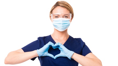 Clinician wearing a mask and protective gloves making a heart with her hands